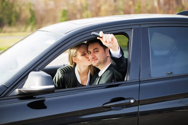 Jovem casal feliz escolhe e compra um carro novo para a família — Fotografia de Stock
