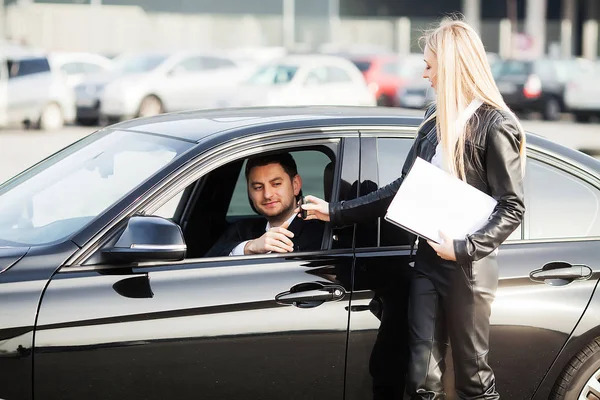 Jovem casal feliz escolhe e compra um carro novo para a família — Fotografia de Stock