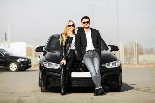 Счастливая молодая пара выбирает и покупает новую машину для семьи — стоковое фото
