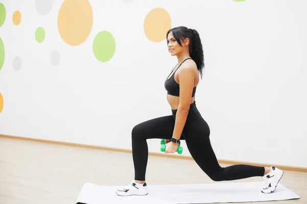 Femme en forme. Jeune femme attrayante faisant des exercices dans la salle de fitness — Photo