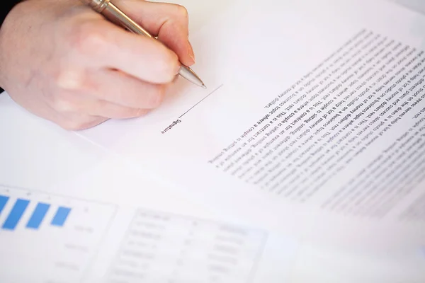 Man signs a contract at a desk in a company office — Stock Photo, Image
