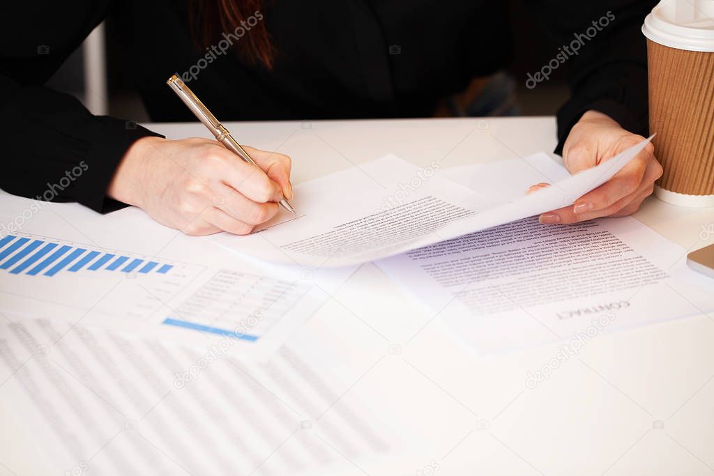 Man signs a contract at a desk in a company office