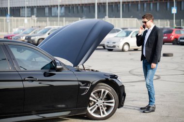 Yolun ortasında kırık arabalı bir adam var.