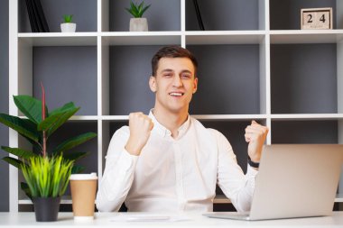 çalışma ofisinde bir dizüstü bilgisayar ile rahat iş adamı