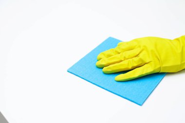 Eldivenli genç bayan ofis masasını temizliyor.