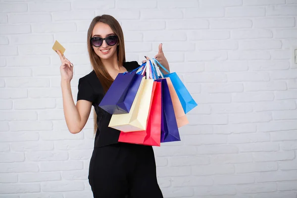 Mulher segurando sacos de compras no fundo claro no feriado de sexta-feira preto — Fotografia de Stock