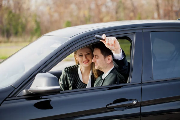 Jovem casal feliz escolhe e compra um carro novo para a família — Fotografia de Stock