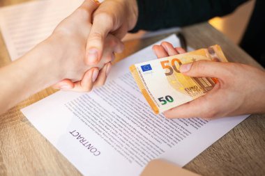 İşadamı, emlak sözleşmesi ve finansal kurumlar için anlaşma yaparken para veriyor.