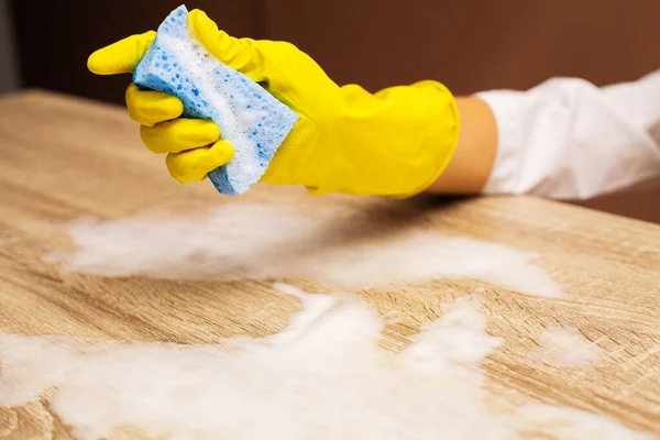 Employee using sponge for cleaning wood table — Stock Photo, Image