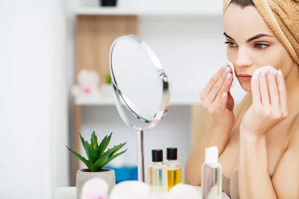 Mujer preparándose para el trabajo haciendo maquillaje matutino en el espejo del baño en casa . — Foto de Stock