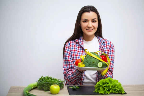 Joven bonita mujer se adhiere a la dieta y tiene un plato de verduras — Foto de Stock