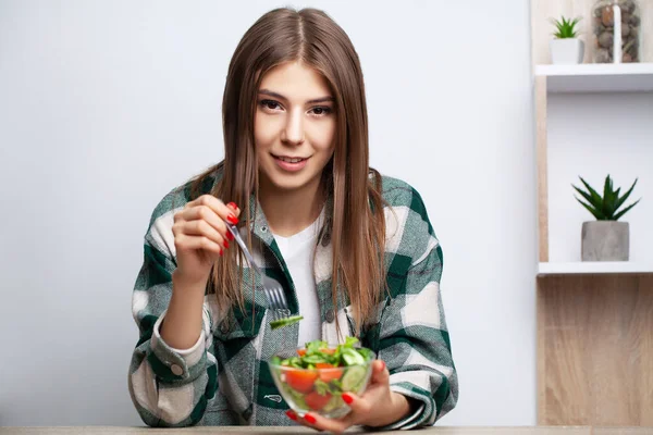 Young pretty woman adheres to diet and chooses healthy food