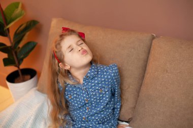 Genç kız yatakta oturuyor.