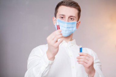 Genç doktor virüs testleriyle test tüpleri tutuyor..