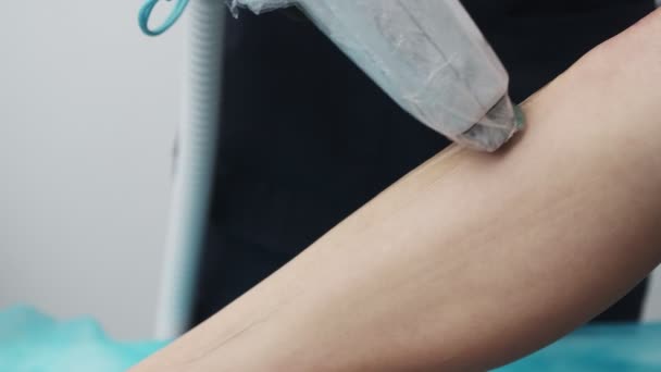 Primer plano del cosmetólogo haciendo depilación del pie, el dispositivo se envuelve, además, con película protectora para una mayor higiene del cliente — Vídeo de stock