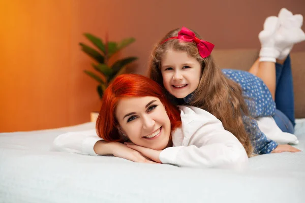 Mama i córka odpoczywają w łóżku w domu — Zdjęcie stockowe