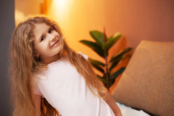 Kleines Mädchen auf dem Bett im Zimmer — Stockfoto