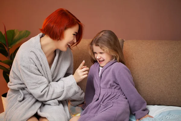 Mom makes daughter on the bed at home manicure