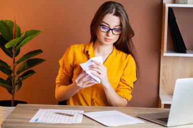 Ofisteki bilgisayarın başında çalışan yorgun kadın.