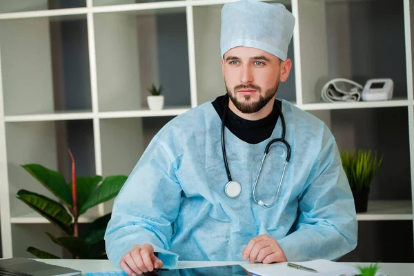 의사는 진료실에 있는 테이블에서 일한다. — 스톡 사진