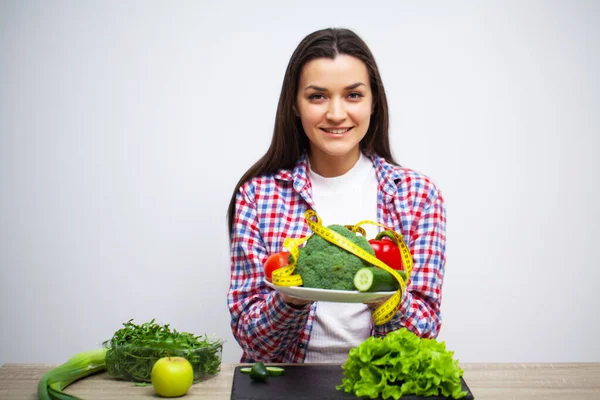 Concepto de alimentación saludable y dieta, niña sosteniendo verduras en la pared blanca de fondo — Foto de Stock