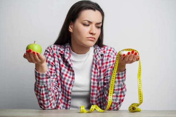 Kvinna gör ett val mellan hälsosam och skadlig mat — Stockfoto