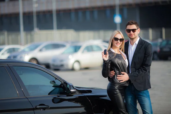 Glada unga par väljer och köper en ny bil för familjen. — Stockfoto