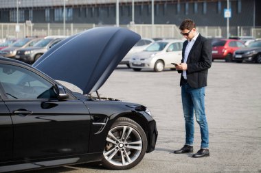 Yolun ortasında kırık arabalı bir adam var..