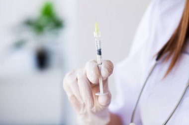Kadın doktor elinde bir şırınga dolusu