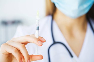 Kadın doktor elinde bir şırınga dolusu