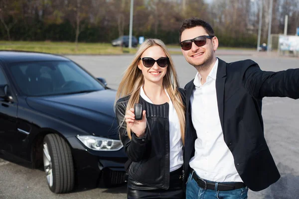 Счастливая молодая пара выбирает и покупает новую машину для семьи . — стоковое фото