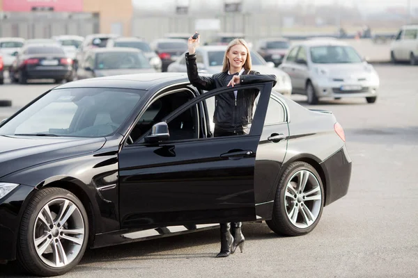 Молодая счастливая женщина купила новый современный автомобиль — стоковое фото