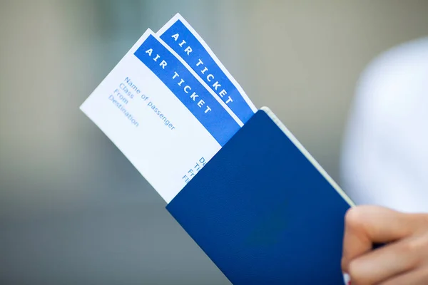 Женщина держит билеты на самолет рядом с аэропортом в паспорте . — стоковое фото