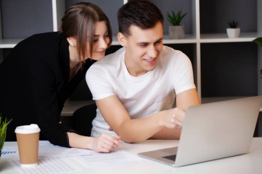 Kadın ve erkek ofiste bir projede birlikte çalışıyorlar.