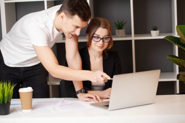 Kadın ve erkek ofiste bir projede birlikte çalışıyorlar.