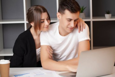 Kadın ve erkek ofiste bir projede birlikte çalışıyorlar.