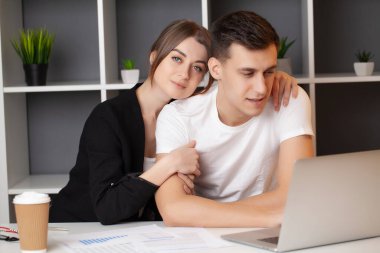 Kadın ve erkek ofiste bir projede birlikte çalışıyorlar.