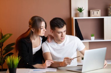 Kadın ve erkek ofiste bir projede birlikte çalışıyorlar.