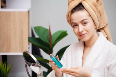 Sevimli kız banyoda yüzüne makyaj yapıyor.