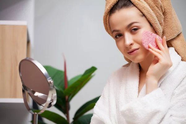 Nettes Mädchen macht Make-up für das Gesicht im Badezimmer — Stockfoto