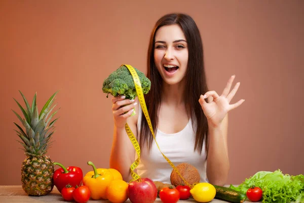 Portrait of young beautiful woman with vegetables, fruits and measuring tape — 图库照片