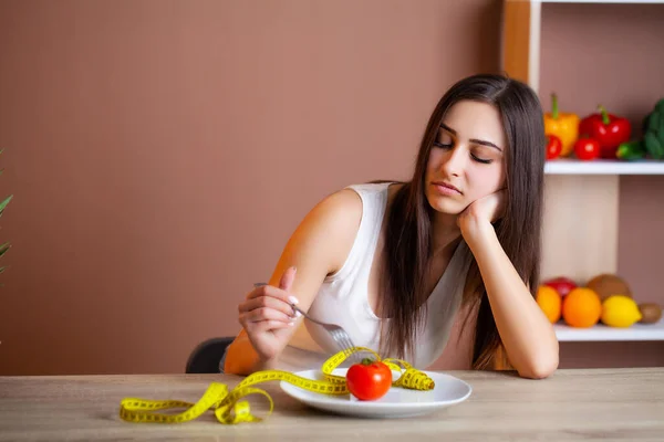 토마토를 가지고 있고 그 위에 줄자를 놓은 아름다운 여자의 사진 — 스톡 사진