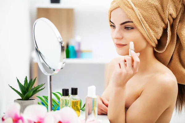 Gadis manis menempatkan makeup di wajah di kamar mandi — Stok Foto