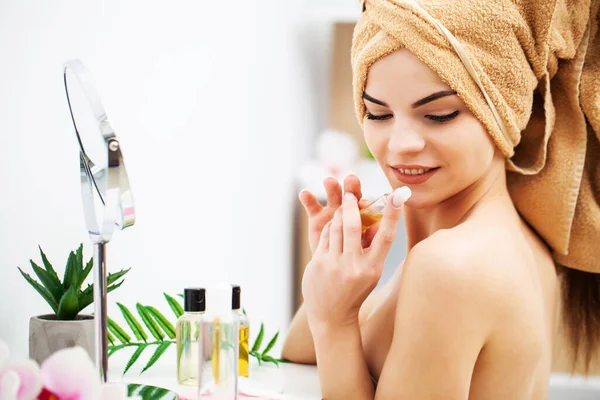 Schattig meisje zet make-up op het gezicht in de badkamer — Stockfoto