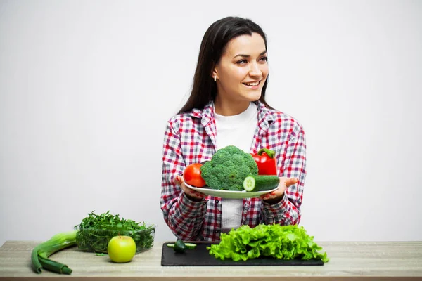 Begreppet hälsosam kost och diet flicka hålla grönsaker på bakgrund vit vägg — Stockfoto