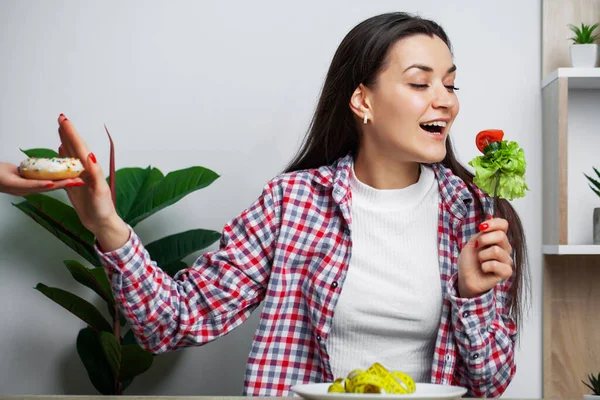 Girl makes a choice between healthy and harmful food — Stock Photo, Image