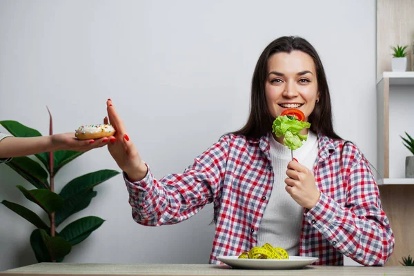 Flicka gör ett val mellan hälsosam och skadlig mat — Stockfoto