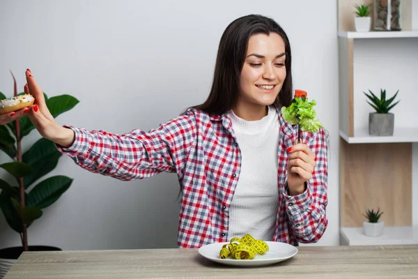 Flicka gör ett val mellan hälsosam och skadlig mat — Stockfoto