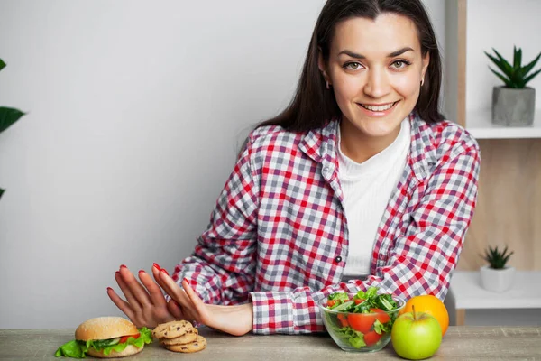 Flicka gör ett val mellan hälsosam och skadlig mat — Stockfoto