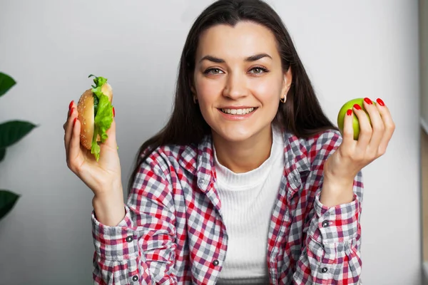 Flicka gör ett val mellan hälsosam och skadlig mat — Stockfoto